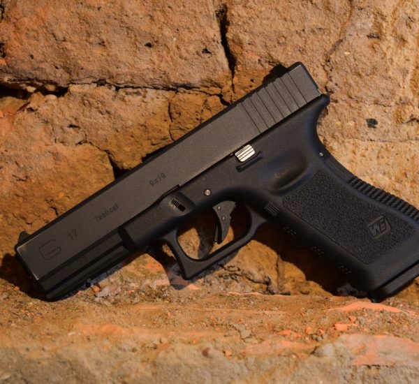 Airsoft pistol resting against a textured wall