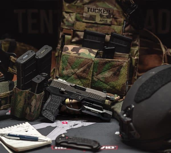 Airsoft equipment and a camouflage plate carrier laid out for packing